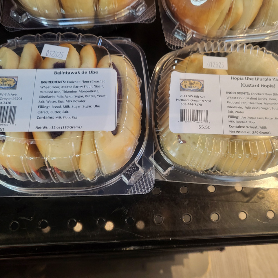 Two plastic containers of Filipino Balintawak de Ube and Hopia Ube pastries with ingredient labels.