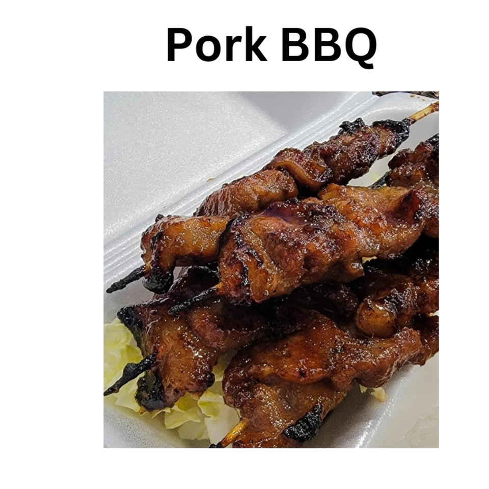 Close-up of several skewers of glistening, dark brown Filipino pork BBQ in a white takeout container.
