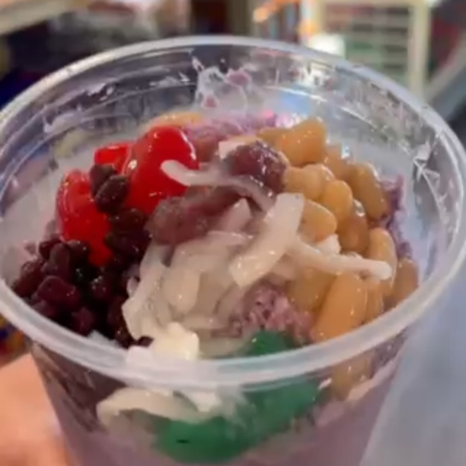 Close-up of Kuya’s Islander Cuisine's colorful Halo-Halo dessert in a clear plastic cup.
