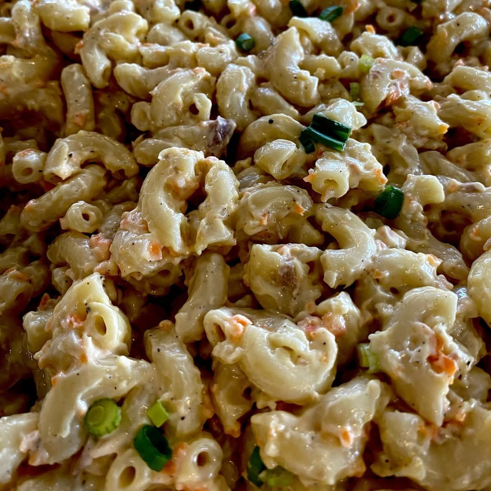 Close-up of creamy Filipino macaroni salad with elbow pasta, carrots, and green onions.
