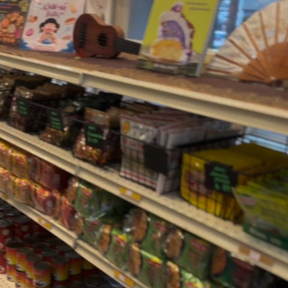 Shelves filled with Filipino groceries, including canned goods, packaged snacks, and decorative items.