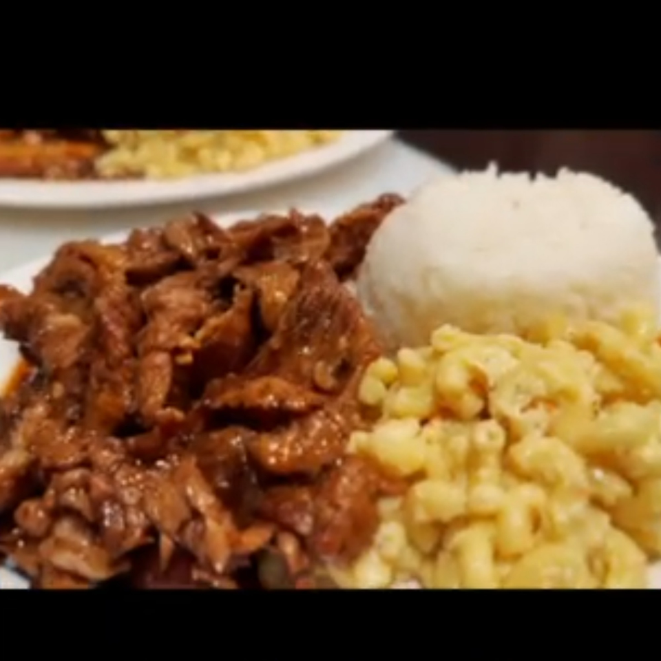 Filipino adobo with white rice and macaroni and cheese on a white plate.